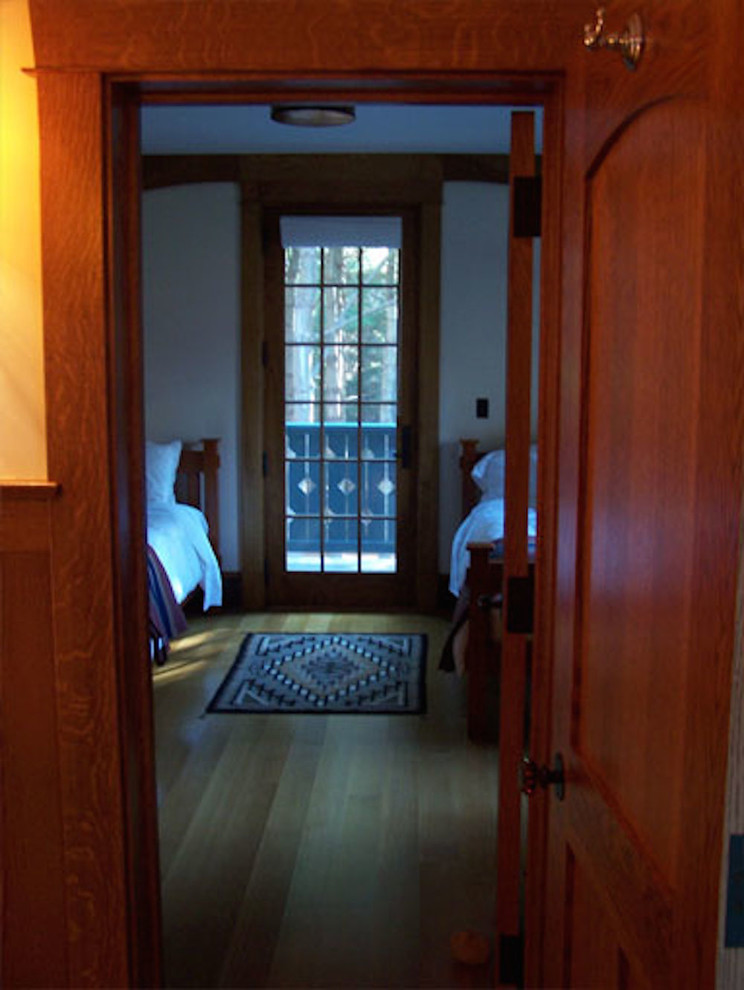 Immagine di una camera degli ospiti stile rurale di medie dimensioni con pareti beige, pavimento in legno massello medio, nessun camino e pavimento marrone
