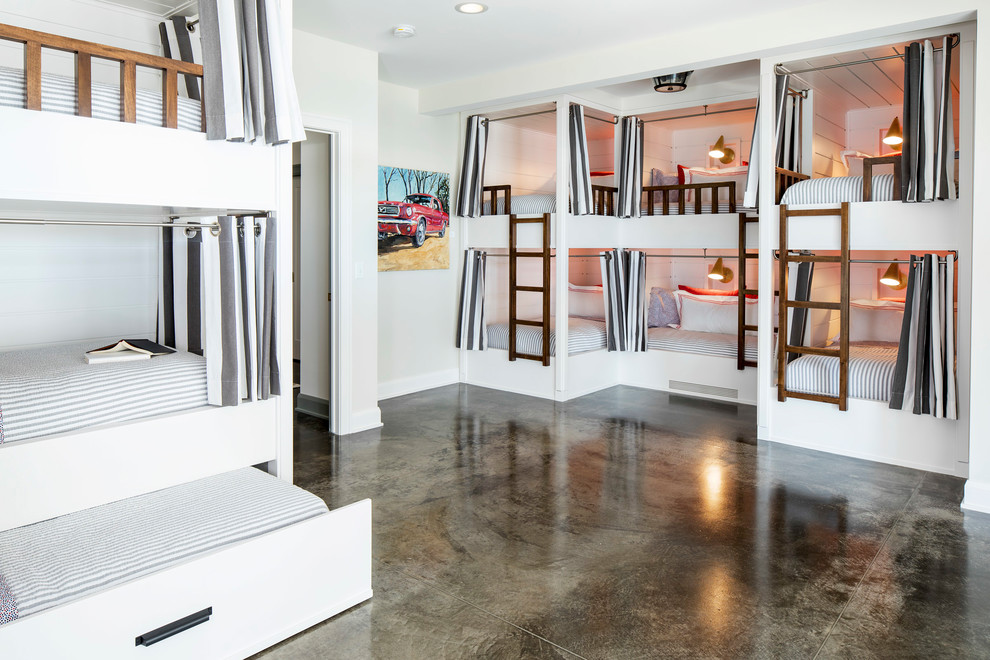 ミネアポリスにある広いビーチスタイルのおしゃれな客用寝室 (白い壁、コンクリートの床、暖炉なし、グレーの床) のインテリア