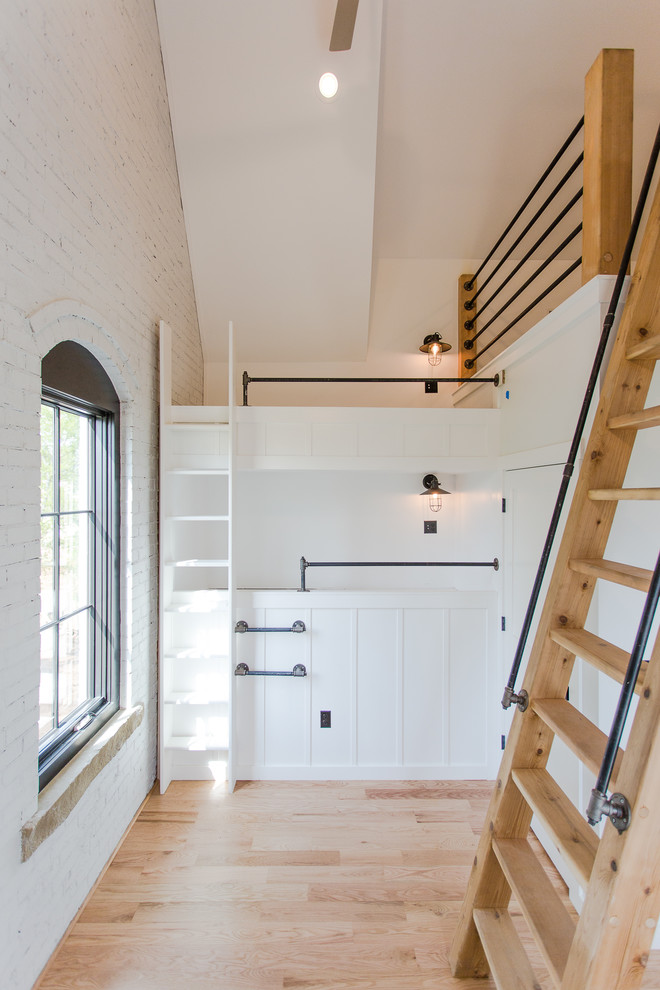 Diseño de dormitorio tipo loft clásico renovado de tamaño medio sin chimenea con paredes blancas, suelo de madera clara y suelo rojo