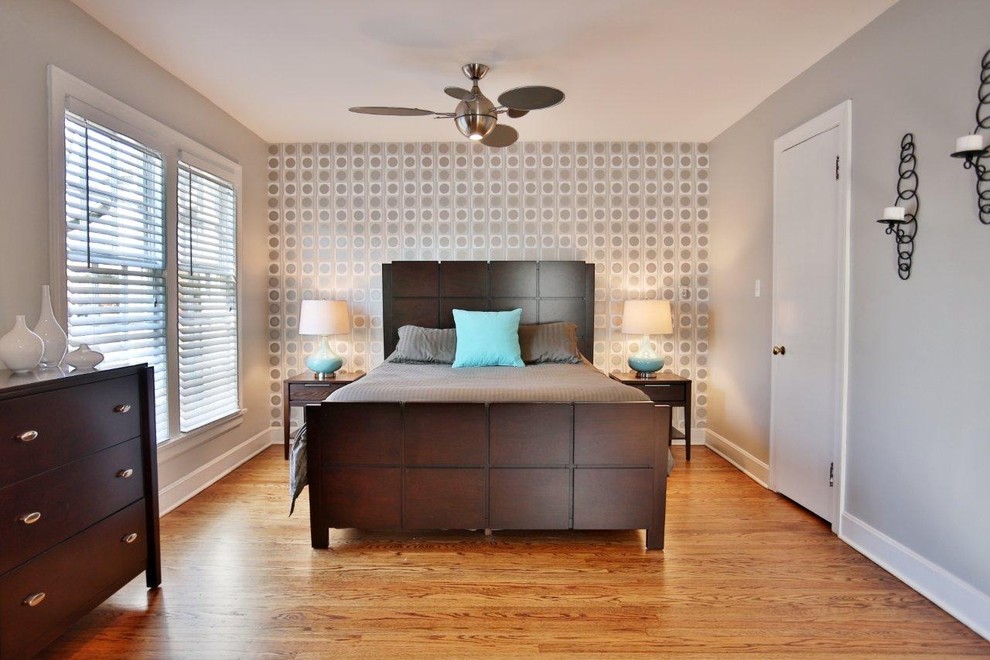 Foto di una camera da letto contemporanea con pareti grigie e pavimento in legno massello medio