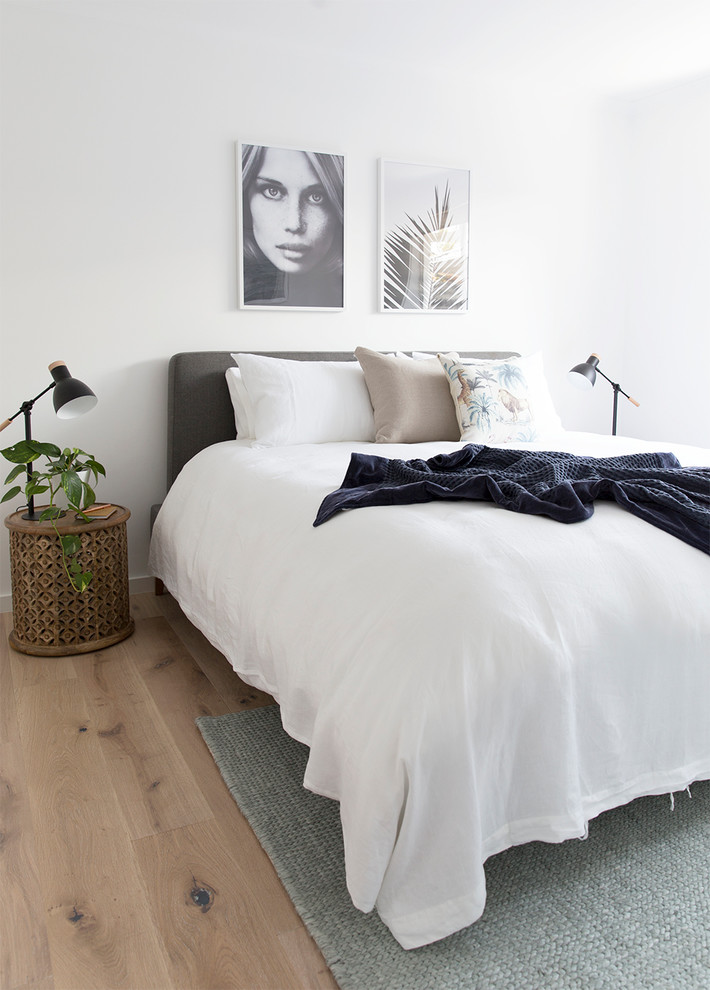 Maritimes Schlafzimmer mit weißer Wandfarbe und hellem Holzboden in Brisbane