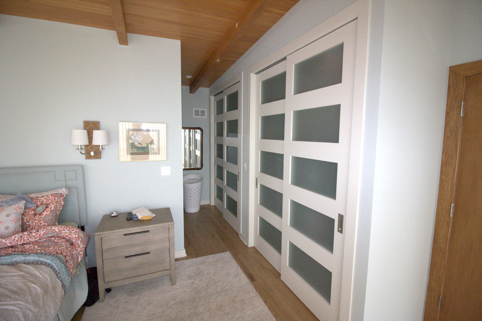 Exemple d'une chambre parentale chic de taille moyenne avec un mur gris, parquet clair, aucune cheminée et un sol marron.