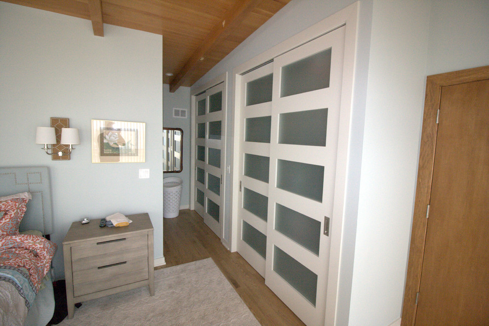 Aménagement d'une chambre parentale classique de taille moyenne avec un mur gris, parquet clair, aucune cheminée et un sol marron.