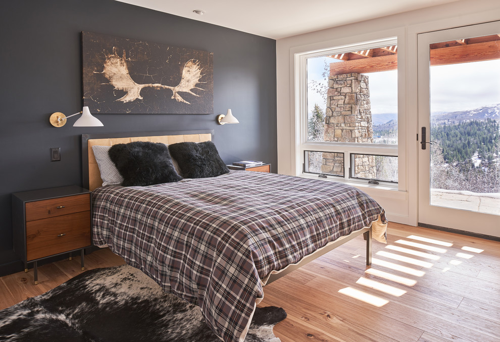 Rustikales Schlafzimmer mit schwarzer Wandfarbe, braunem Holzboden und braunem Boden in Sonstige
