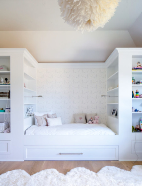 Modelo de habitación de invitados contemporánea grande sin chimenea con paredes beige, suelo de madera clara y suelo beige