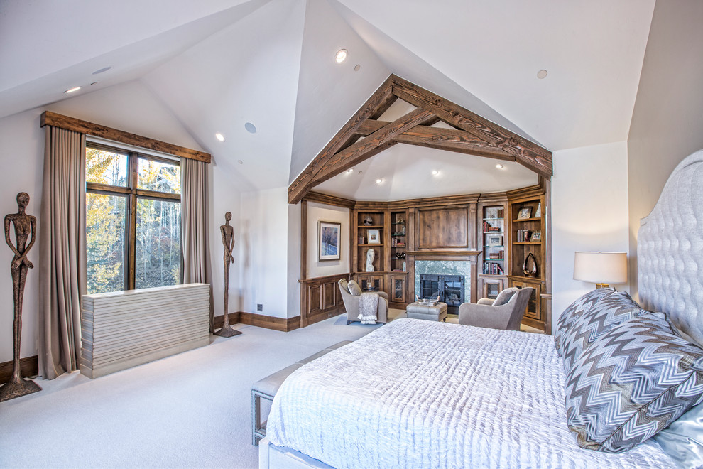 Réalisation d'une grande chambre chalet avec un mur blanc, une cheminée standard, un manteau de cheminée en pierre et un sol beige.