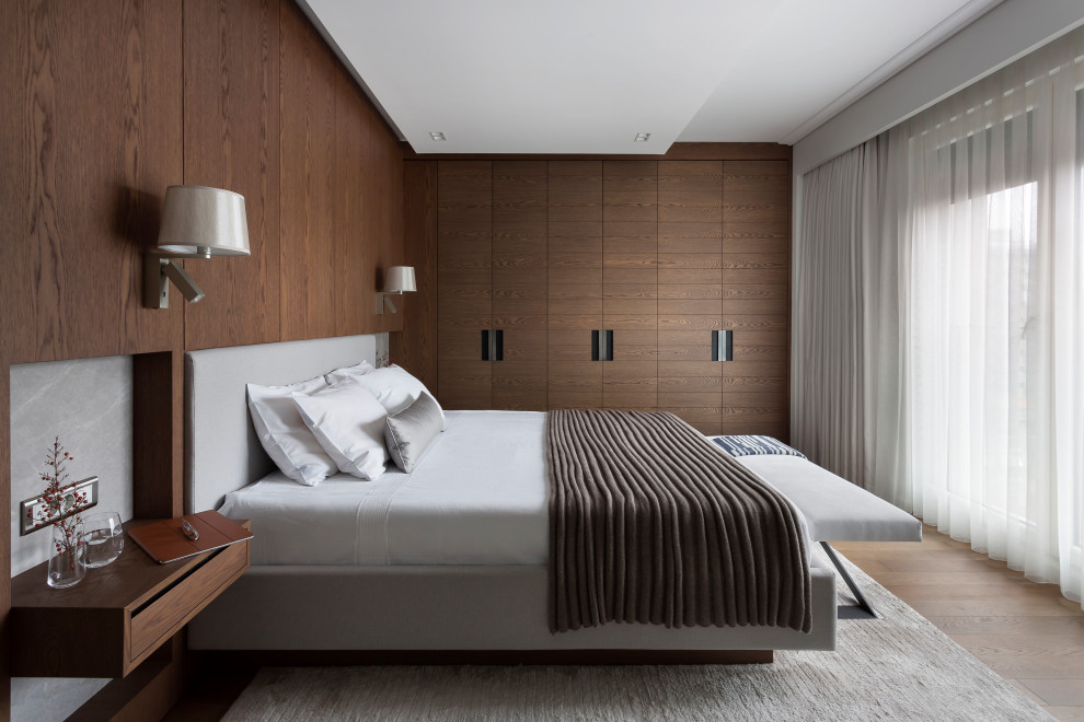 Réalisation d'une chambre design avec un mur marron, un sol en bois brun et un sol marron.