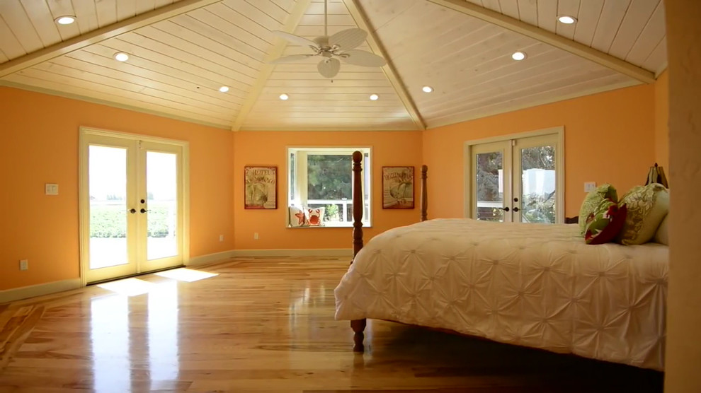 サンフランシスコにある広いビーチスタイルのおしゃれな主寝室 (オレンジの壁、淡色無垢フローリング、暖炉なし) のインテリア