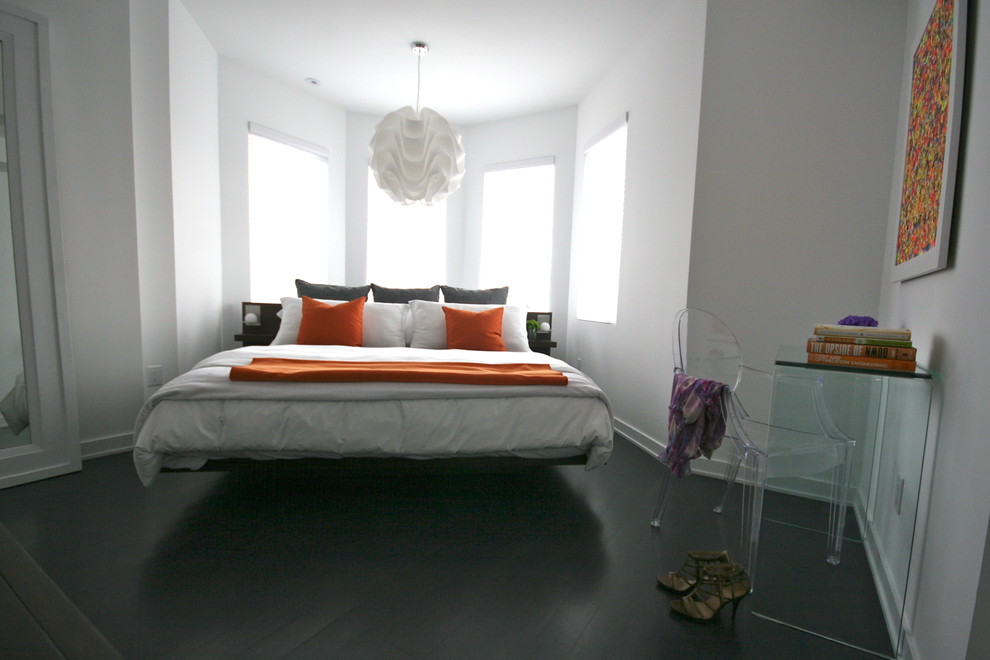 Foto på ett funkis sovrum, med vita väggar och svart golv