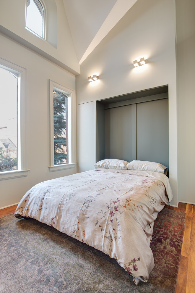 Foto de habitación de invitados tradicional renovada de tamaño medio sin chimenea con suelo de madera en tonos medios y paredes blancas