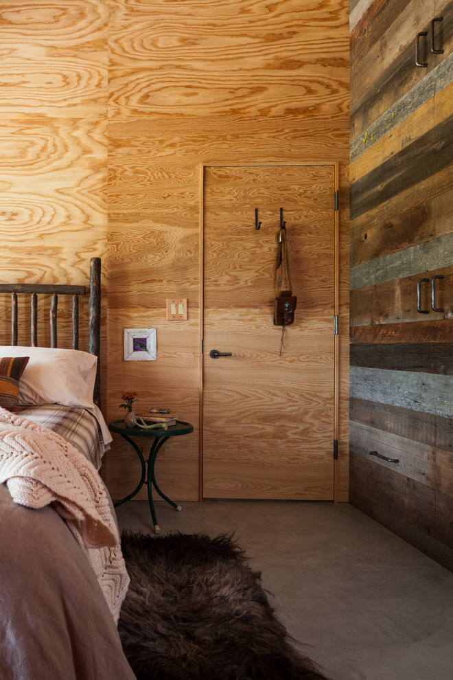 Mid-sized mountain style concrete floor bedroom photo in Other