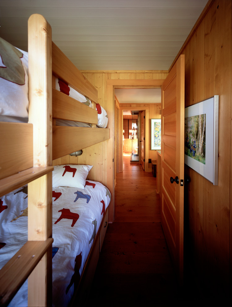 Cette image montre une petite chambre d'amis traditionnelle avec un sol en bois brun et aucune cheminée.