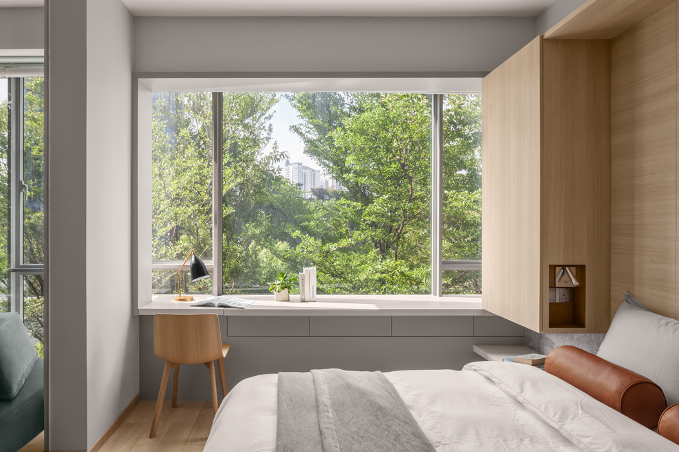 На фото: спальня в современном стиле с серыми стенами, светлым паркетным полом и бежевым полом
