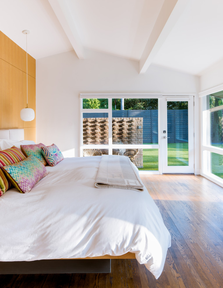 Exemple d'une chambre rétro avec un mur blanc, un sol en bois brun, un sol marron et un plafond voûté.