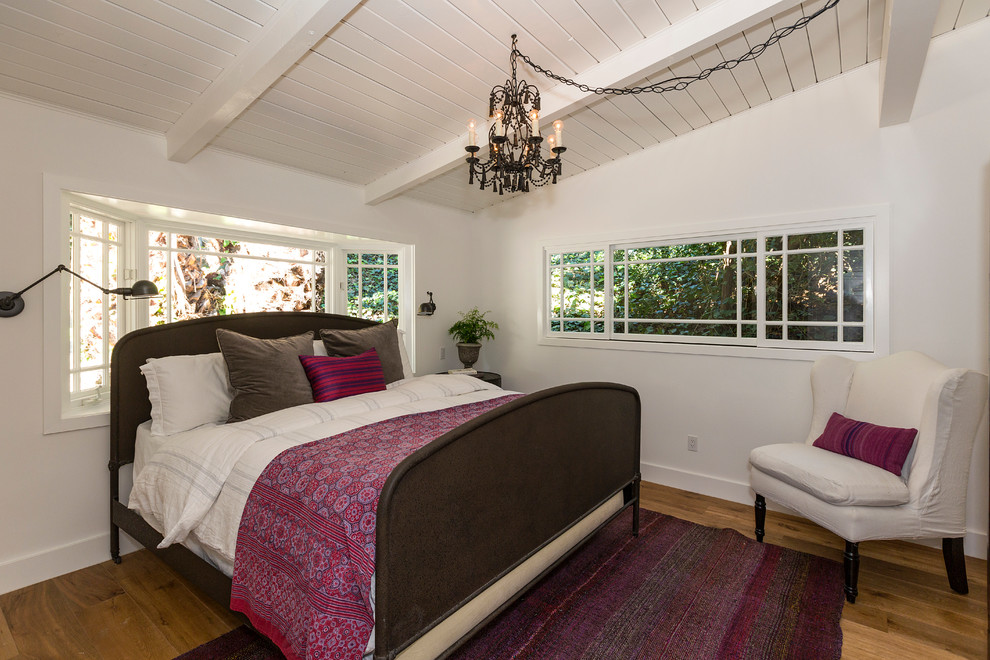 Réalisation d'une chambre champêtre de taille moyenne avec un mur blanc et un sol en bois brun.