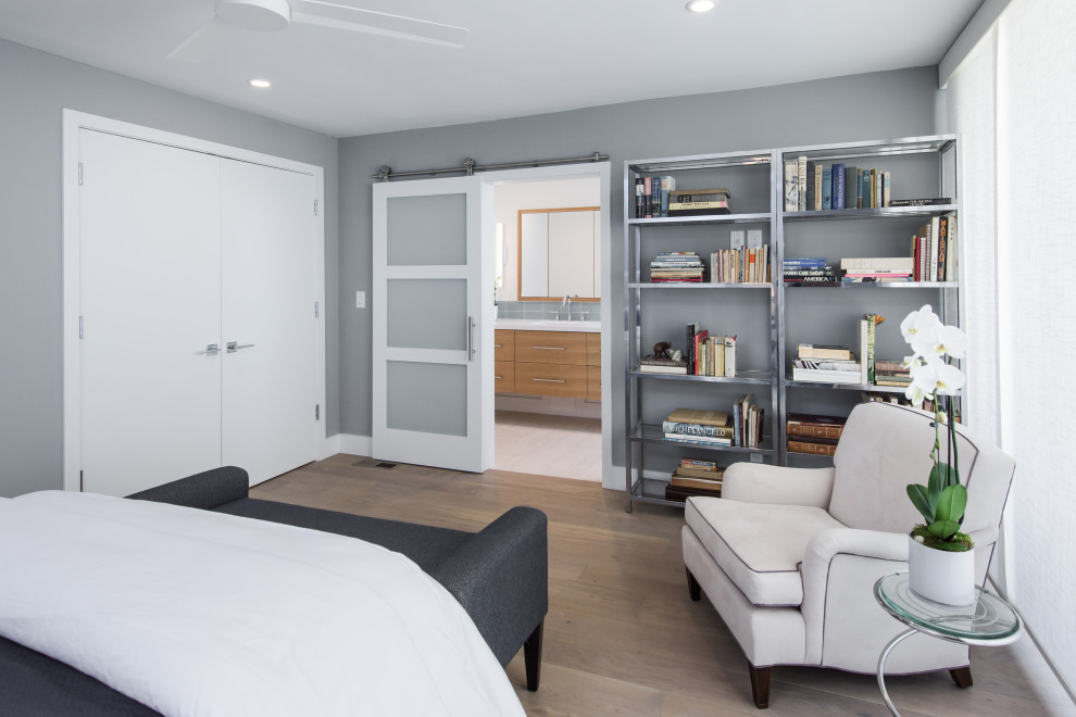 Foto de dormitorio principal costero de tamaño medio con paredes grises, suelo de madera en tonos medios y suelo marrón