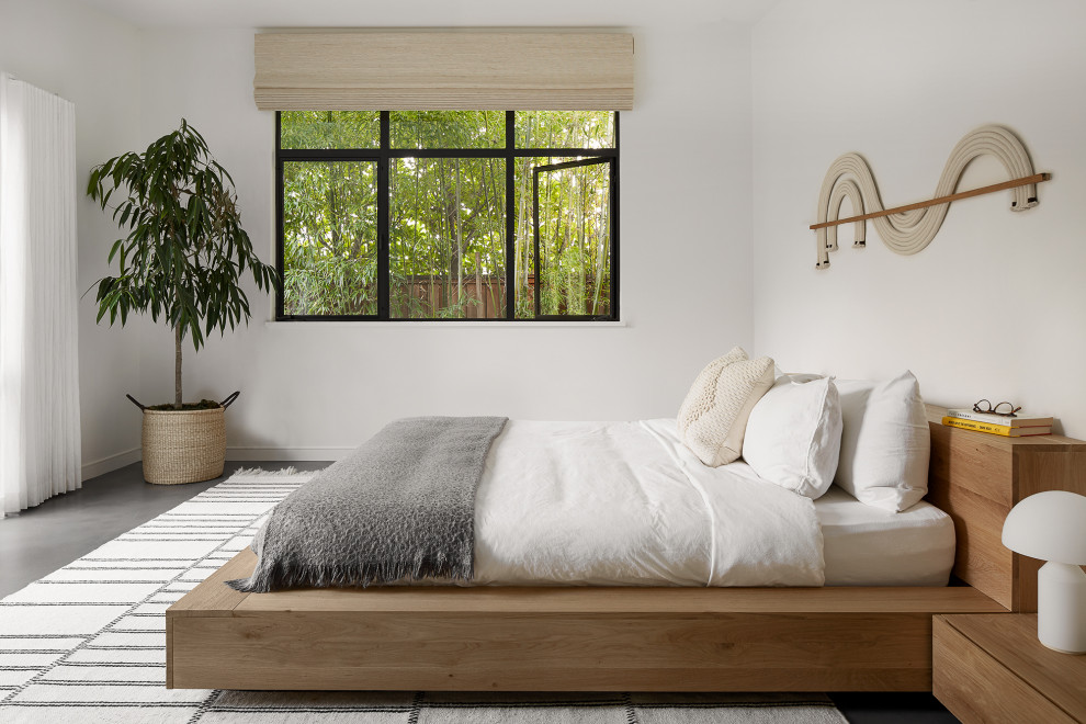 Пример оригинального дизайна: спальня в скандинавском стиле с белыми стенами, бетонным полом и серым полом