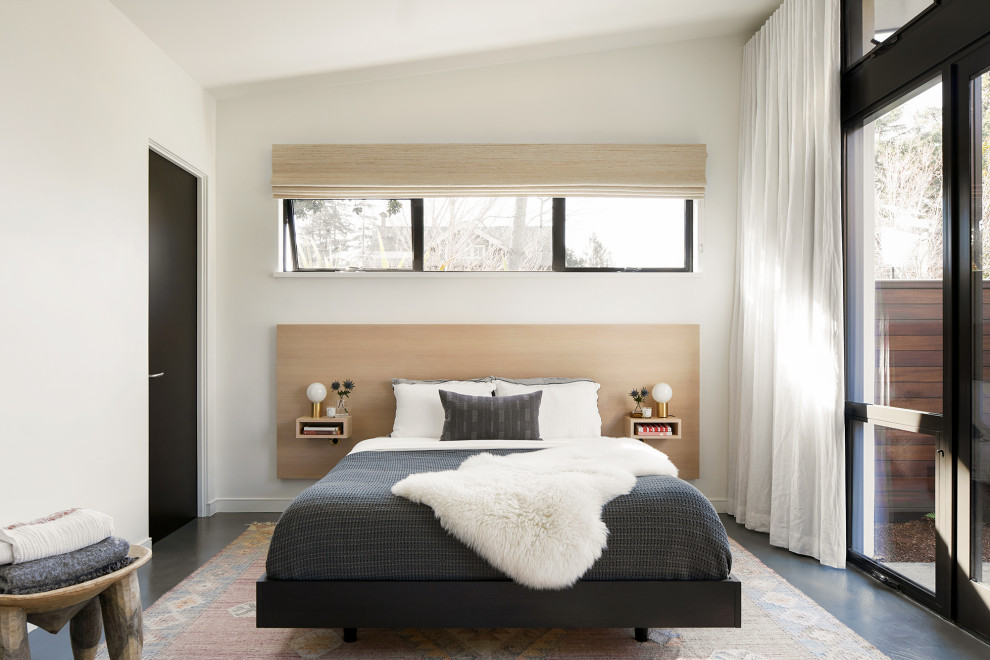 Exempel på ett sovrum, med vita väggar, betonggolv och grått golv