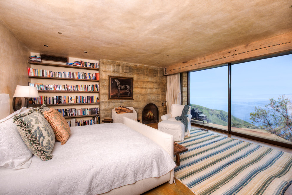 Example of a large tuscan master medium tone wood floor bedroom design in San Francisco with beige walls, a standard fireplace and a concrete fireplace