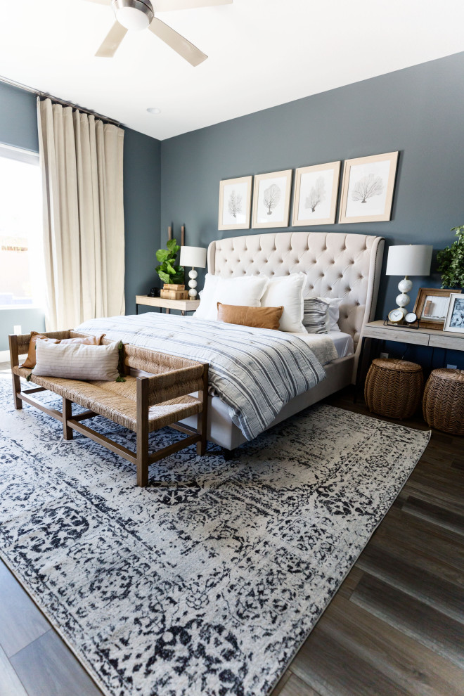 Diseño de dormitorio principal clásico renovado grande sin chimenea con paredes azules, suelo de madera en tonos medios y suelo marrón