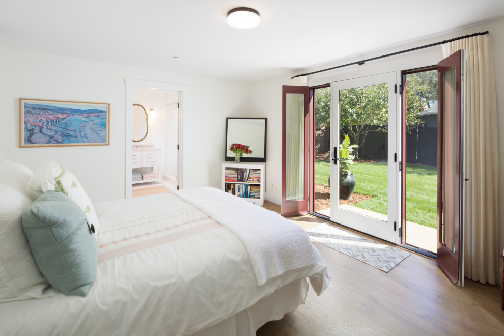 Maritimes Schlafzimmer mit weißer Wandfarbe, braunem Holzboden und braunem Boden in Santa Barbara