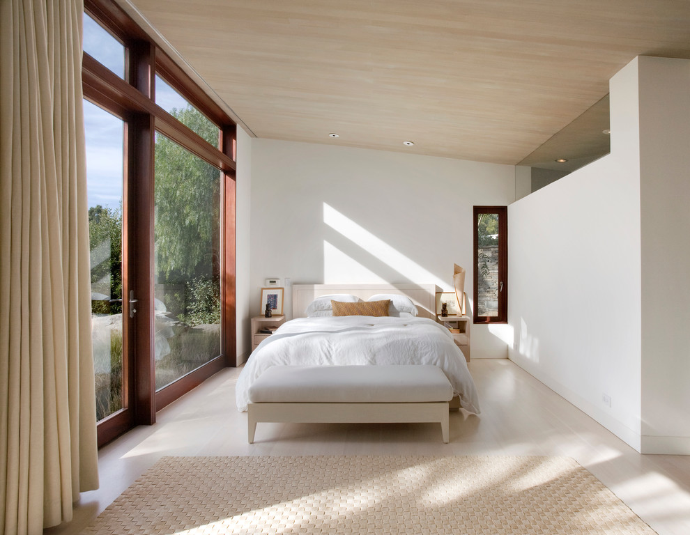 На фото: спальня в скандинавском стиле с белыми стенами и светлым паркетным полом с