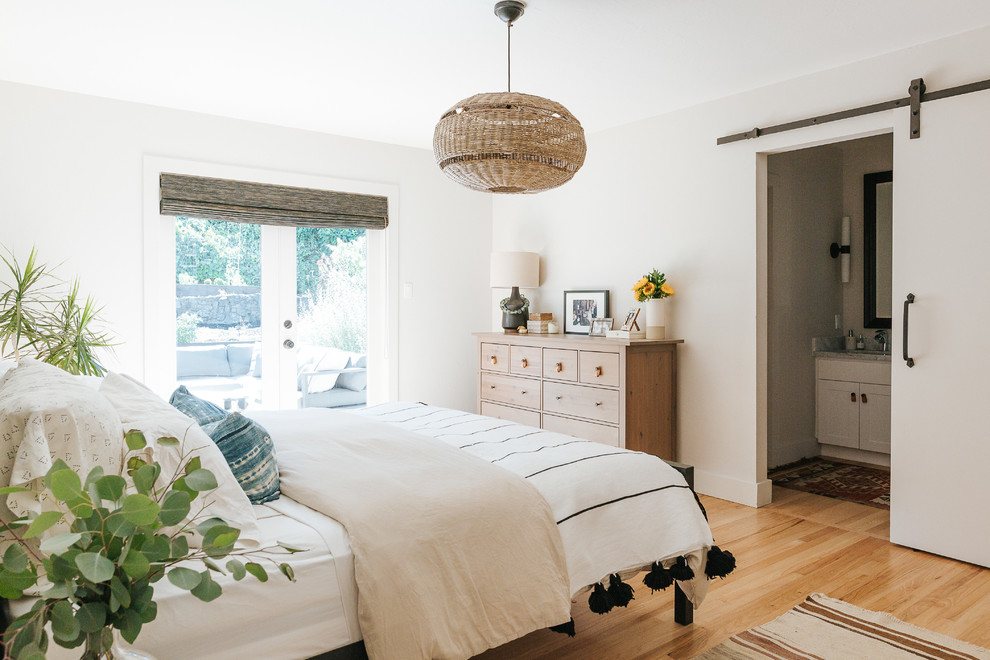 Example of a trendy master light wood floor and beige floor bedroom design in San Francisco with white walls
