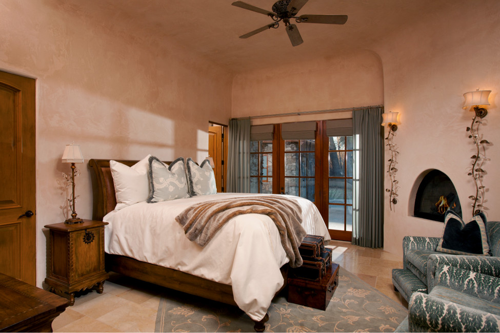 Идея дизайна: большая гостевая спальня (комната для гостей) в средиземноморском стиле с бежевыми стенами, стандартным камином и полом из известняка