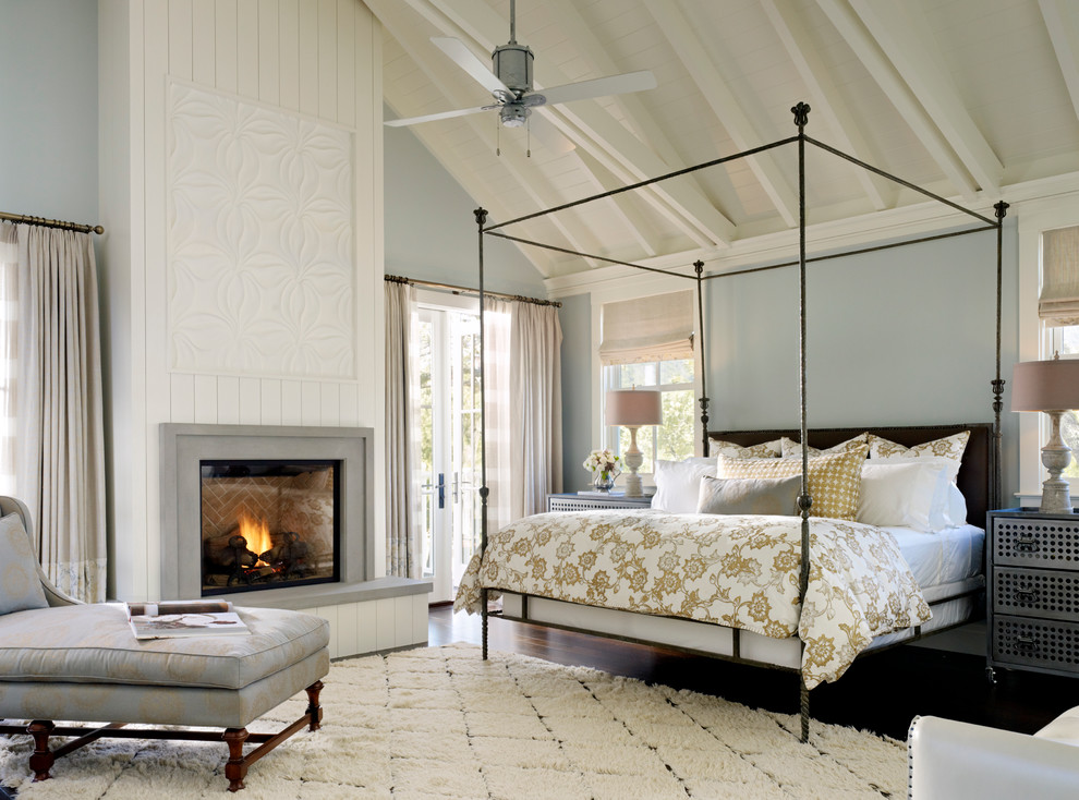 Imagen de dormitorio de estilo de casa de campo con paredes azules, suelo de madera oscura y todas las chimeneas
