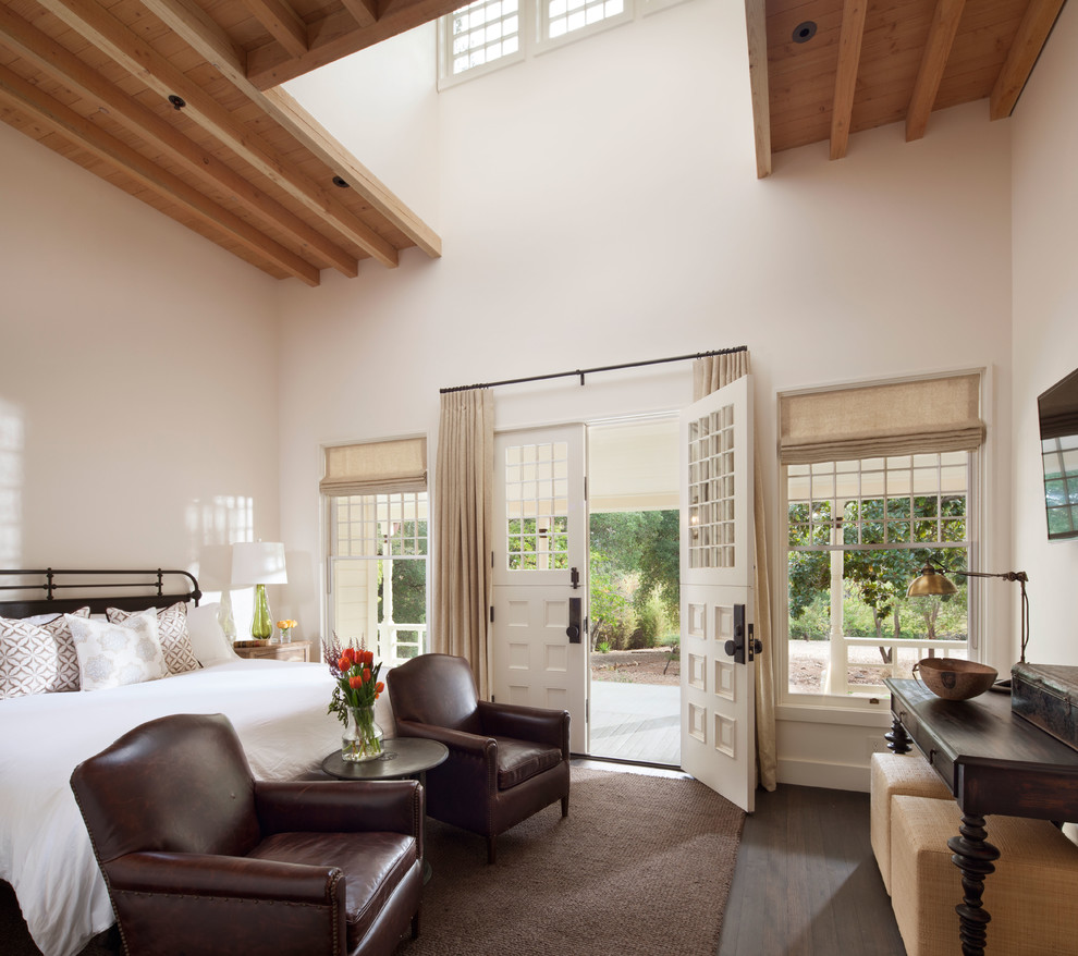 Diseño de dormitorio campestre con paredes blancas, suelo de madera oscura y suelo marrón