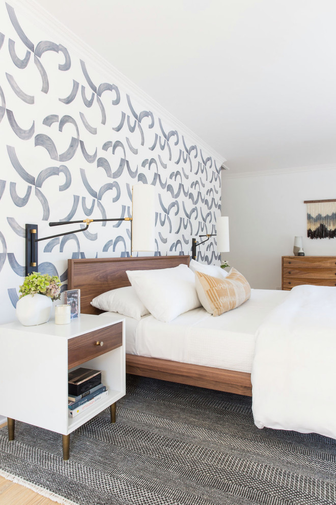 Modelo de dormitorio principal contemporáneo grande con paredes multicolor, suelo de madera clara, suelo beige y papel pintado