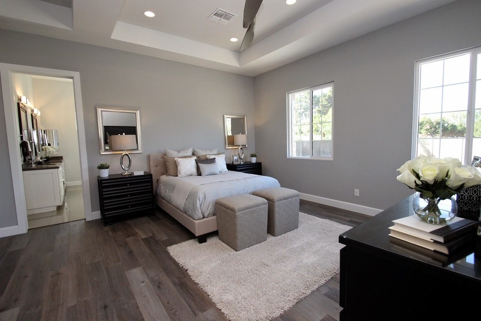 Modern master and grey and silver bedroom in Phoenix with grey walls and medium hardwood flooring.