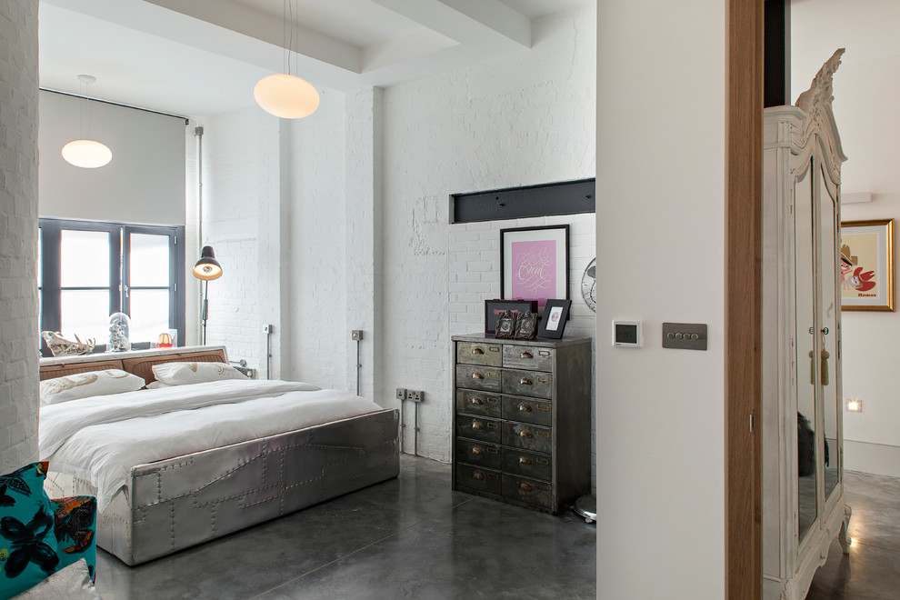 Inspiration for an urban bedroom in London with white walls, concrete flooring and grey floors.