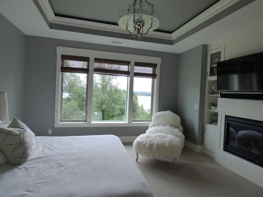 Aménagement d'une grande chambre classique avec un mur gris, une cheminée standard, un manteau de cheminée en métal et un sol gris.