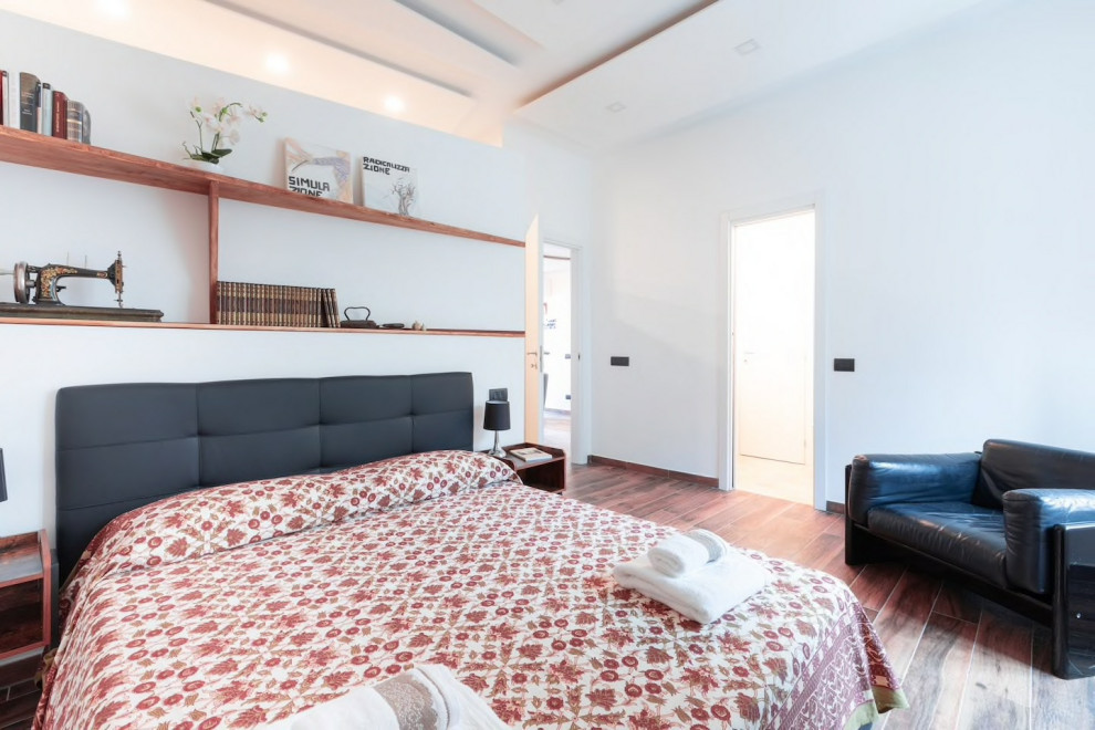 Diseño de dormitorio principal contemporáneo de tamaño medio con paredes blancas, suelo de baldosas de porcelana y suelo marrón