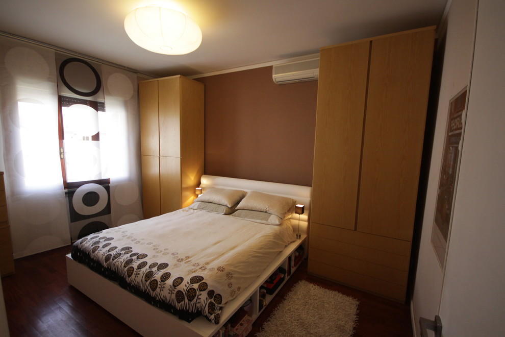 На фото: маленькая хозяйская спальня в современном стиле с коричневыми стенами и темным паркетным полом для на участке и в саду с