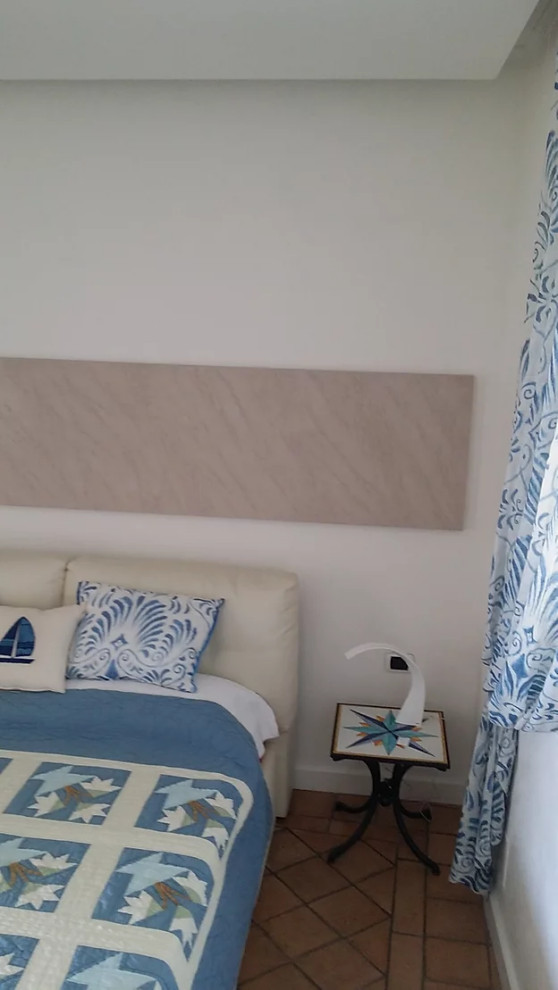 Ejemplo de dormitorio principal mediterráneo pequeño sin chimenea con paredes blancas, suelo de baldosas de terracota y suelo beige