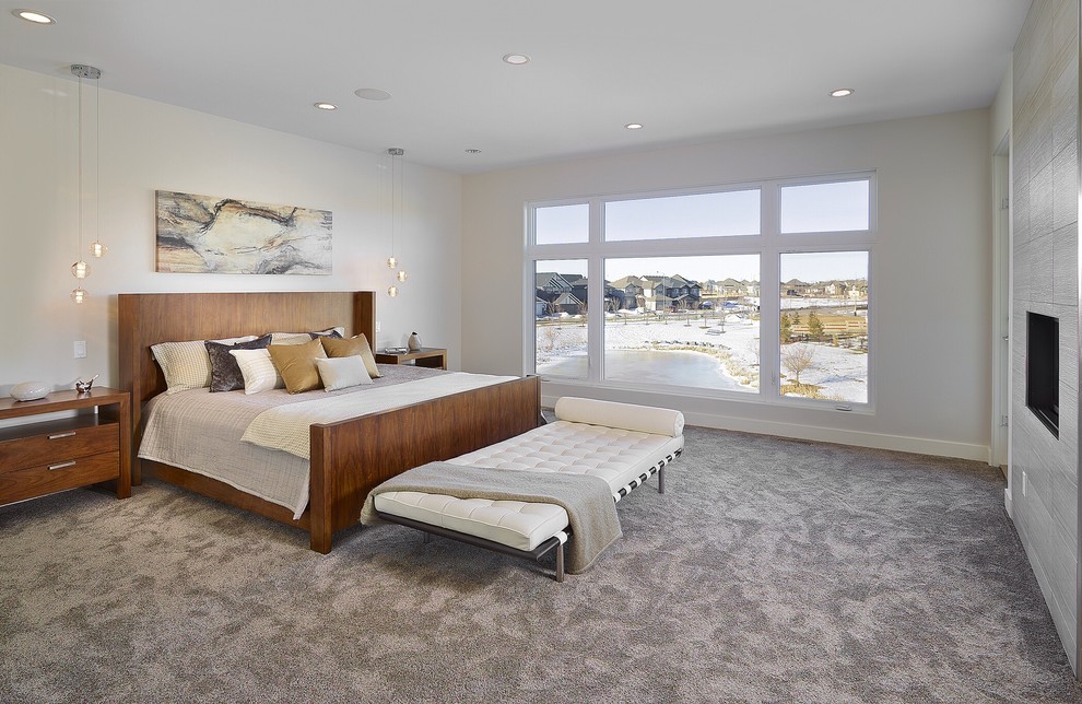 Großes Modernes Hauptschlafzimmer mit weißer Wandfarbe, Teppichboden, gefliester Kaminumrandung und Kamin in Edmonton
