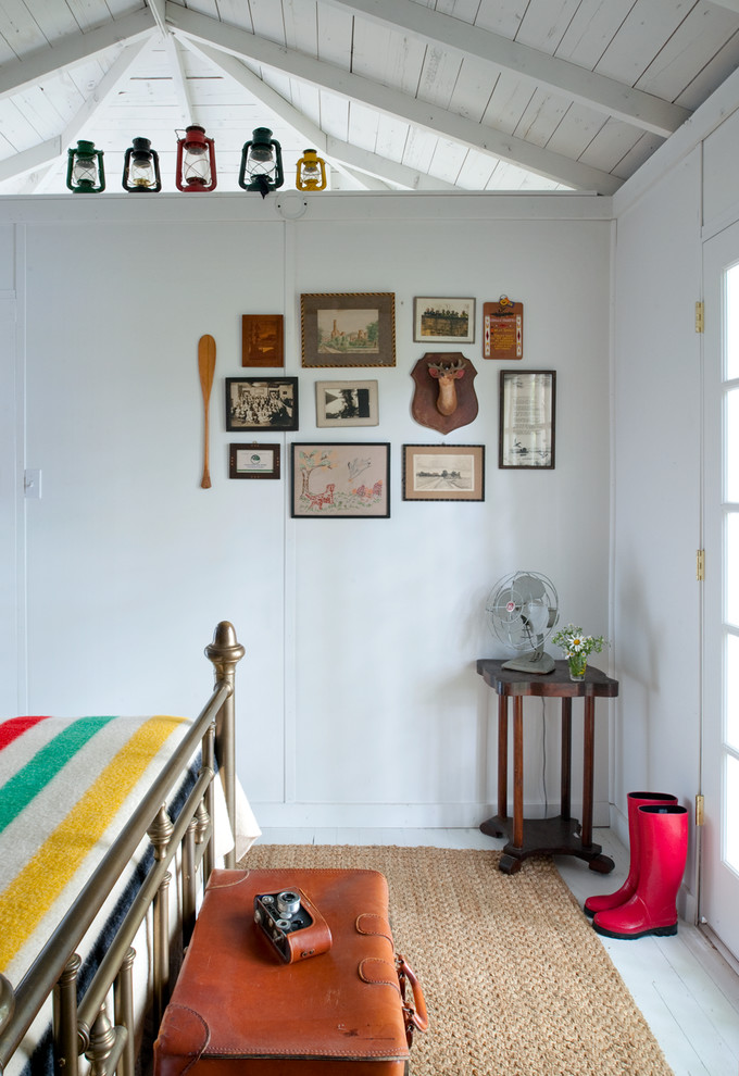 Maritimes Schlafzimmer mit weißer Wandfarbe und gebeiztem Holzboden in Chicago