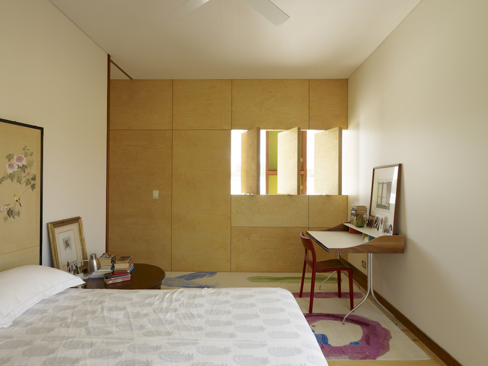 Imagen de dormitorio contemporáneo de tamaño medio con paredes blancas, suelo de madera clara y con escritorio