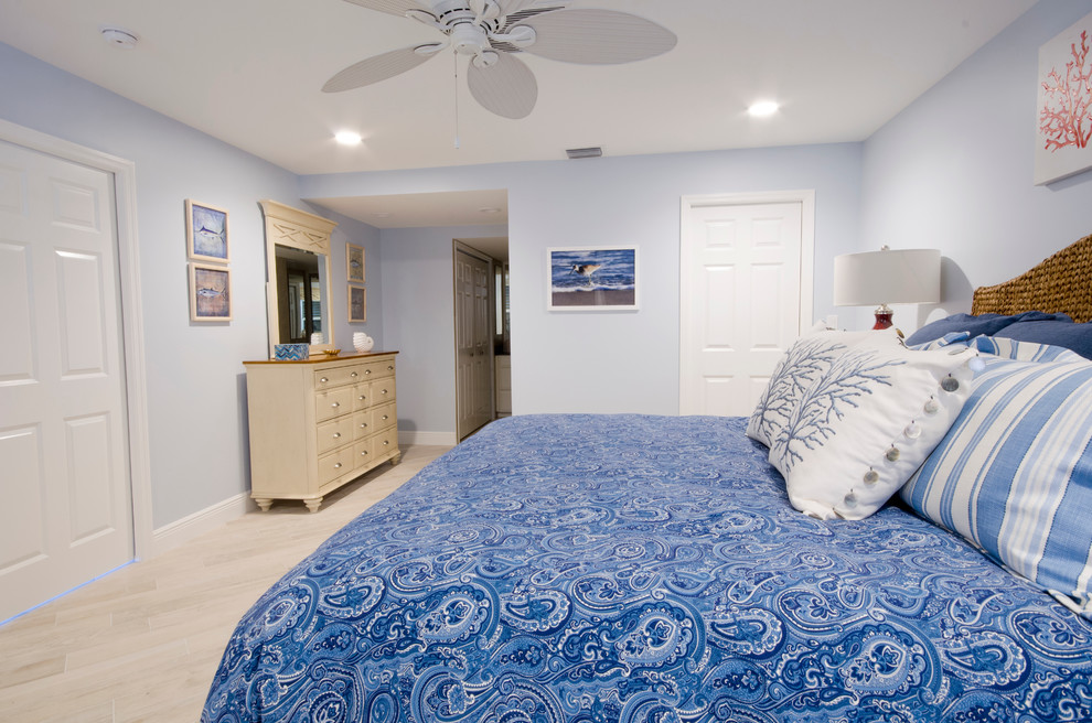 Ejemplo de dormitorio principal marinero grande con paredes azules y suelo de baldosas de cerámica
