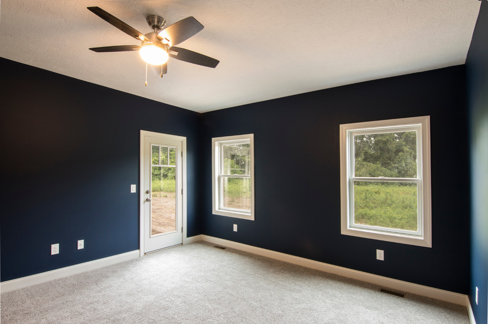 Cette image montre une chambre d'amis rustique avec un mur bleu, parquet foncé et un sol marron.