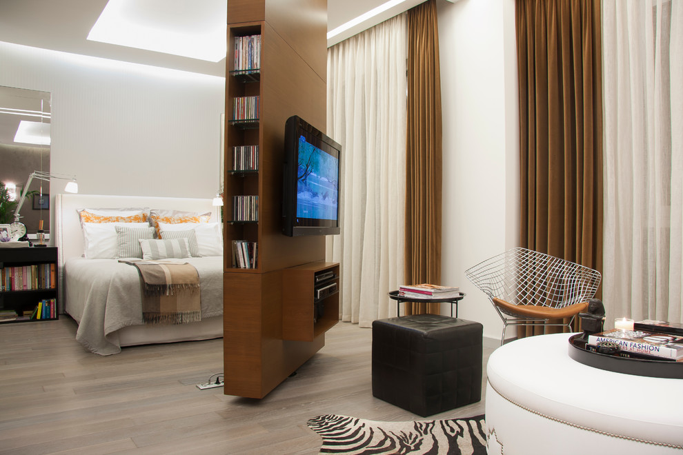Пример оригинального дизайна: хозяйская спальня в современном стиле с белыми стенами и телевизором без камина