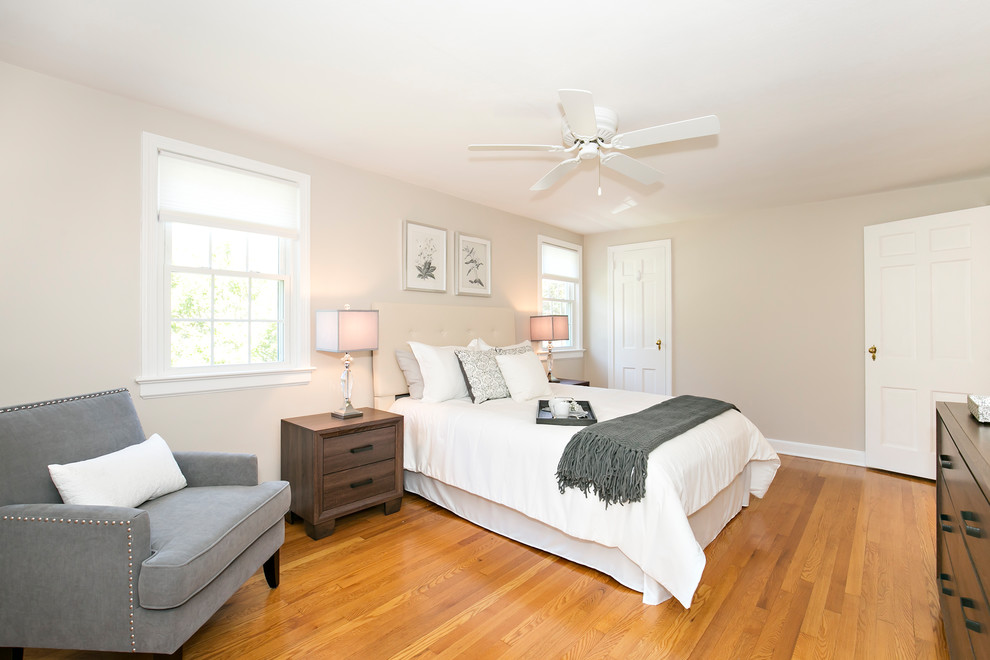 Imagen de dormitorio principal tradicional renovado con paredes beige, suelo de madera en tonos medios y suelo beige