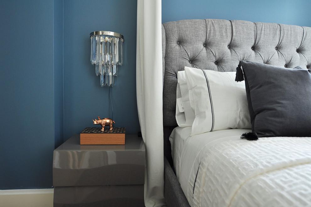 Small bohemian master bedroom in New York with blue walls and medium hardwood flooring.