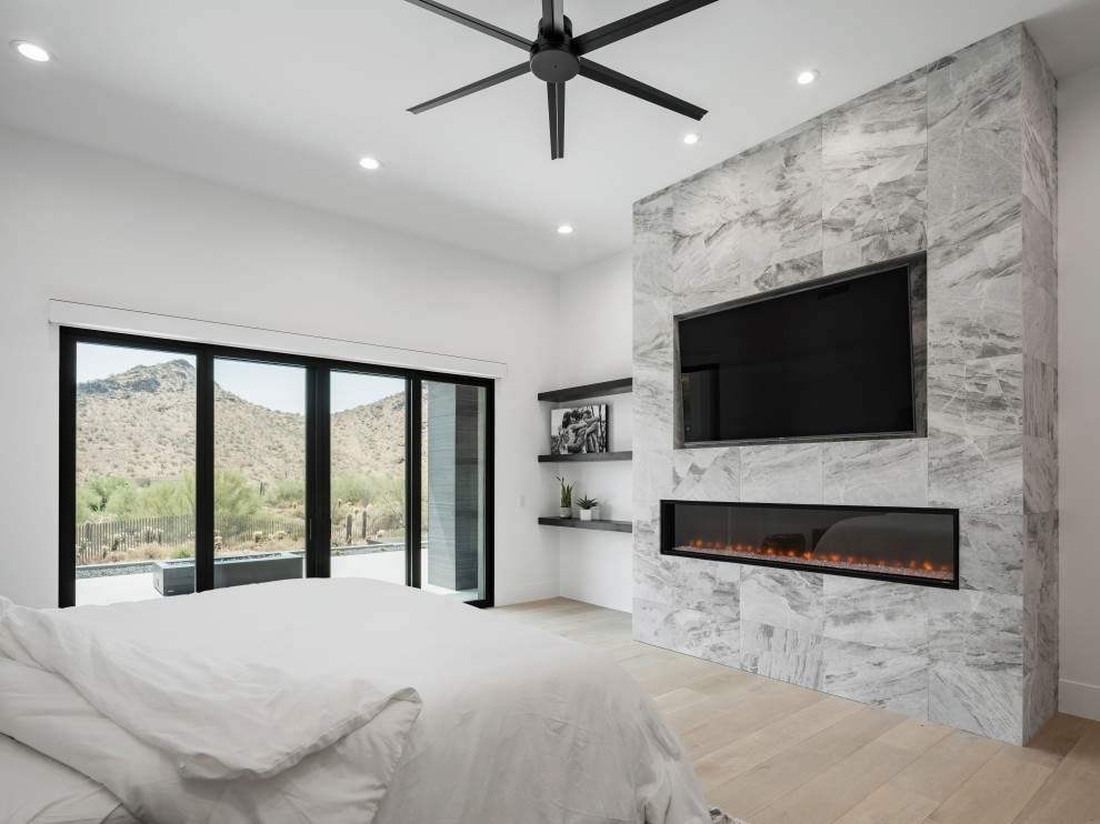 Großes Modernes Hauptschlafzimmer mit weißer Wandfarbe, hellem Holzboden, Kamin, gefliester Kaminumrandung, beigem Boden und eingelassener Decke in Phoenix