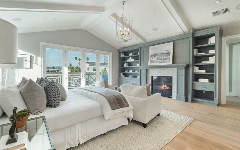 Imagen de dormitorio tradicional renovado con paredes grises, suelo de madera en tonos medios y todas las chimeneas