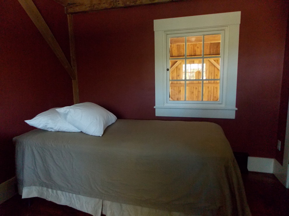 Exemple d'une petite chambre d'amis nature avec un mur rouge et un sol en bois brun.