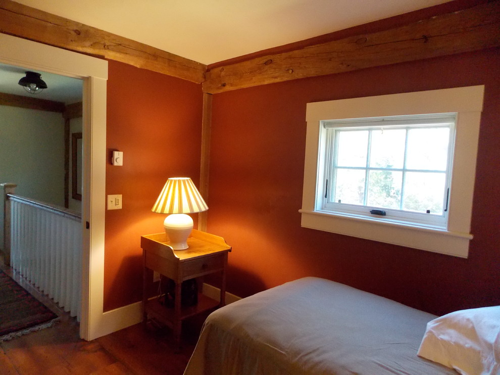 Imagen de habitación de invitados campestre pequeña con paredes rojas y suelo de madera en tonos medios