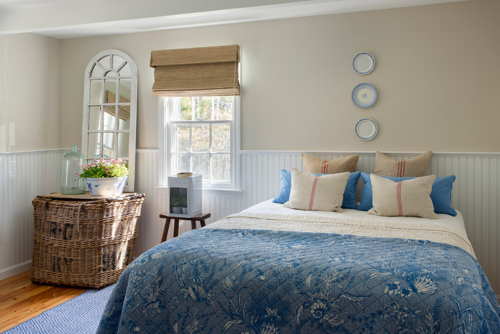 Imagen de dormitorio costero de tamaño medio con paredes beige y suelo de madera en tonos medios